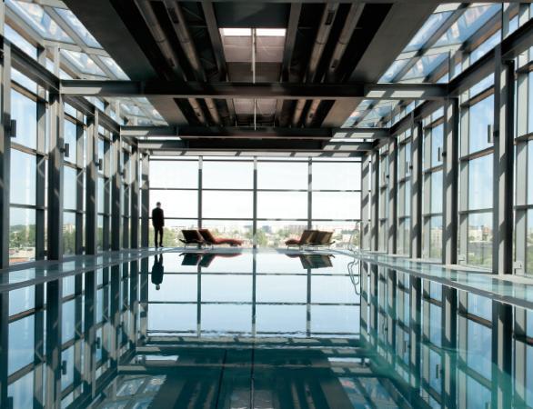 Szklana bryła basenu na ostatnim piętrze hotelu Andel's z widokiem na rynek odrestaurowanej Manufakt