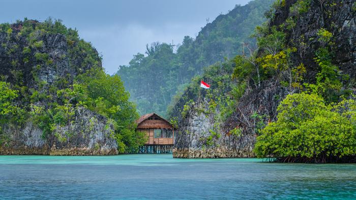Indonezja, drewniana chatka nad brzegiem morza na Papui